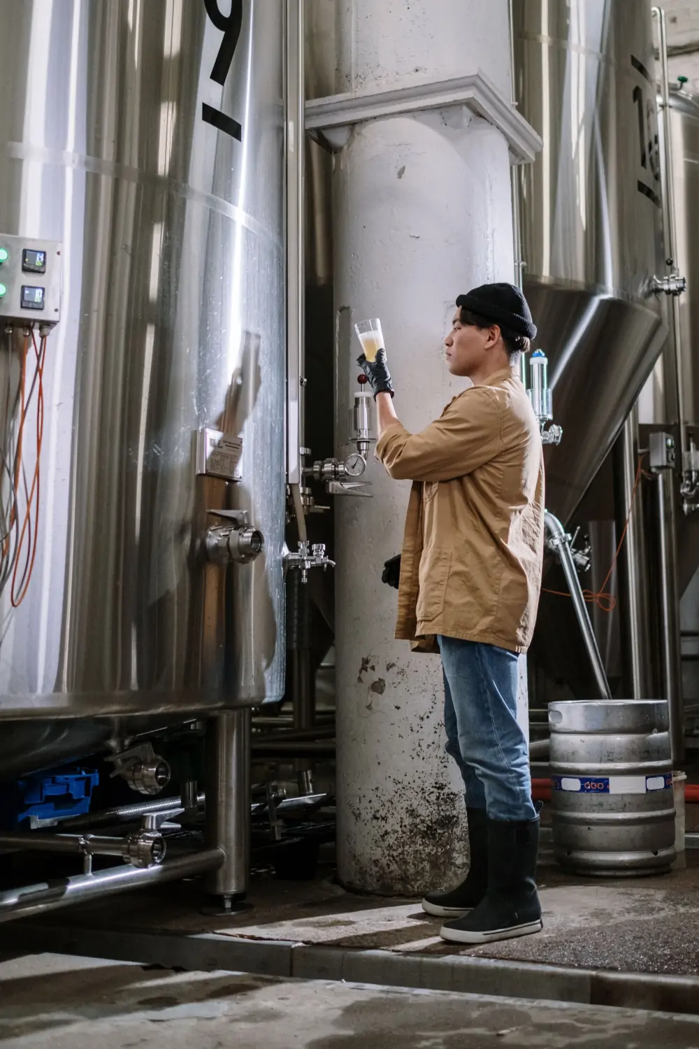 Operator checking a stainless-steel tank in a dairy processing room